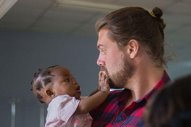 Joel Witwer with a baby at CURE Zambia